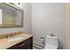 Bathroom with a dark wood vanity and granite top, toilet, and mirror at 2800 Kalmia Ave # B209, Boulder, CO 80301