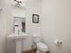 Neat bathroom with white toilet, sink, and mirror, complemented by light wood flooring at 5810 W 39Th Pl, Wheat Ridge, CO 80212