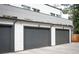 Three gray garages attached to a gray and white house with small windows, concrete driveway at 5810 W 39Th Pl, Wheat Ridge, CO 80212
