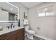 Updated bathroom featuring a walk-in shower, hexagon tile flooring, and a modern toilet at 7076 S Newland St, Littleton, CO 80128