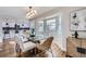 Bright dining room with glass table, bay window, and kitchen views at 7076 S Newland St, Littleton, CO 80128