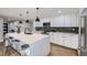 Renovated kitchen boasting white cabinets, hexagon backsplash, and a large island at 7076 S Newland St, Littleton, CO 80128