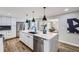 Bright kitchen featuring a spacious island, stainless steel appliances, and hardwood floors at 7076 S Newland St, Littleton, CO 80128