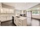 Modern kitchen boasts stainless appliances, white cabinets, mosaic backsplash, and hardwood floors at 2247 S Lima Ct, Aurora, CO 80014