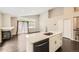 An open floor plan kitchen features white cabinets, a center island, and stainless steel appliances at 2247 S Lima Ct, Aurora, CO 80014