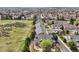 Townhomes with attached garages line a community with green lawns and natural grass open space at 6701 W Yale Ave, Lakewood, CO 80227
