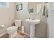 This half-bath features modern fixtures, a pedestal sink, and convenient toilet paper storage at 6701 W Yale Ave, Lakewood, CO 80227