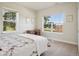 Bright bedroom featuring large windows with outdoor views, complemented by neutral walls and carpet at 6701 W Yale Ave, Lakewood, CO 80227