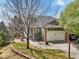 Charming home with stone accents, a two-car garage, manicured lawn, and walkway to the front door at 6701 W Yale Ave, Lakewood, CO 80227