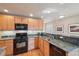 Well-equipped kitchen with granite countertops, wooden cabinets and stainless steel appliances at 6701 W Yale Ave, Lakewood, CO 80227