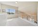 Light-filled upper landing with wood railing, plush carpet, and scenic window view at 6701 W Yale Ave, Lakewood, CO 80227