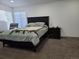 Comfortable bedroom with a dark wood bed frame, bedside table, and a large window with natural light at 9133 W Cedar Dr # A, Lakewood, CO 80226