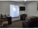 Bedroom with dark wood desk, black TV, and window with privacy shade at 9133 W Cedar Dr # A, Lakewood, CO 80226