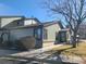 Street view of home's exterior featuring well-kept lawn, brick accents, mature trees, and inviting entrance at 9133 W Cedar Dr # A, Lakewood, CO 80226