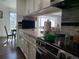 Modern kitchen featuring white cabinets, stainless steel appliances, and a view of the dining area beyond at 9133 W Cedar Dr # A, Lakewood, CO 80226