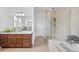 Modern bathroom featuring a glass enclosed shower, soaking tub, and granite countertop vanity at 7814 S Grand Baker Ct, Aurora, CO 80016