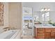 Elegant bathroom with a soaking tub, stylish tile work, and views into the bright Primary bedroom at 7814 S Grand Baker Ct, Aurora, CO 80016