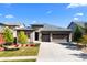 Attractive single-story home showcases stone details, a well-kept lawn, and an expansive driveway to the three-car garage at 7814 S Grand Baker Ct, Aurora, CO 80016