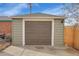 Detached garage with brown door and a spacious driveway at 5065 Eliot St, Denver, CO 80221