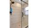 A renovated shower with modern fixtures and hexagonal floor tiles at 5065 Eliot St, Denver, CO 80221