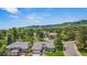 Aerial view of home with mountain views, mature landscaping, and residential street at 10 Oakmont Ln, Littleton, CO 80127