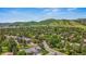 Aerial view of neighborhood showcasing tree coverage, nearby mountains, and residential streets at 10 Oakmont Ln, Littleton, CO 80127