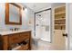 Bathroom featuring a glass shower, white tiled floor, and vanity with baskets at 10 Oakmont Ln, Littleton, CO 80127