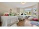 Inviting bedroom featuring two twin beds, bay windows, and hardwood floors at 10 Oakmont Ln, Littleton, CO 80127