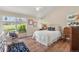 Bright bedroom featuring hardwood floors, a cozy rocking chair, and many windows for natural light at 10 Oakmont Ln, Littleton, CO 80127