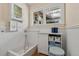 Dog bath with white cabinets, built-in shelving, window, and beadboard wainscoting at 10 Oakmont Ln, Littleton, CO 80127