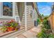 Landscaped side yard with flower planter, stone pathway, mature plants, and neutral siding at 10 Oakmont Ln, Littleton, CO 80127