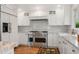 Modern kitchen featuring stainless steel appliances, custom white cabinetry, and a stone countertop at 10 Oakmont Ln, Littleton, CO 80127