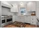 Modern kitchen featuring stainless steel appliances, custom white cabinetry, and a stone countertop at 10 Oakmont Ln, Littleton, CO 80127