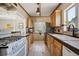 Well-lit kitchen with wooden cabinetry, tiled backsplash, and modern appliances offering functionality and style at 1497 S Garfield St, Denver, CO 80210