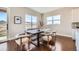 Chic dining area features a dark wood table, modern chairs, large windows, and sliding door to the exterior at 5134 Cupule Trl, Castle Rock, CO 80104