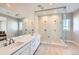 Modern bathroom features a double vanity, a glass-enclosed shower, and neutral tile flooring at 5134 Cupule Trl, Castle Rock, CO 80104