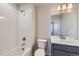 Modern bathroom with gray vanity, white tile, and bathtub at 2370 W 167Th Ln, Broomfield, CO 80023