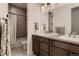 Bathroom with double sink vanity with granite countertops, and tiled shower with curtain at 8868 Geyser Peak Way, Parker, CO 80138