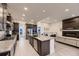 Open concept kitchen with gas range, large island, and view of the living room fireplace at 8868 Geyser Peak Way, Parker, CO 80138