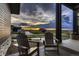 Charming porch view with two chairs, a hanging flower basket, and a scenic sunset backdrop at 8868 Geyser Peak Way, Parker, CO 80138