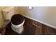 A cozy bathroom with wood-look vinyl flooring and a toilet with a plush seat cover at 47373 Lily Ave, Bennett, CO 80102