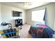 Bright bedroom featuring carpeted floors, ceiling fan, and a large window for natural light at 47373 Lily Ave, Bennett, CO 80102