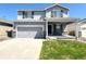 Charming two-story home with a gray exterior, landscaped yard, covered porch, and a two car garage at 47373 Lily Ave, Bennett, CO 80102
