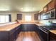 Functional kitchen featuring wooden cabinets, laminate countertops, modern appliances, and a window view at 47373 Lily Ave, Bennett, CO 80102
