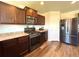 Modern kitchen with stainless steel appliances, wooden cabinetry, and laminate flooring at 47373 Lily Ave, Bennett, CO 80102