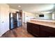 Spacious kitchen area featuring stainless steel appliances, wooden cabinets, and a view of the living room at 47373 Lily Ave, Bennett, CO 80102