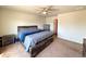 A carpeted main bedroom offers a ceiling fan and modern furnishings at 47373 Lily Ave, Bennett, CO 80102