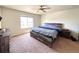 A carpeted main bedroom offers natural light and a modern bed frame with coordinating nightstands at 47373 Lily Ave, Bennett, CO 80102
