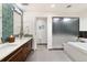 Bright bathroom featuring a double vanity, modern fixtures, and a glass-enclosed shower and tub at 1690 Bassett St # 6, Denver, CO 80202