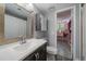 Bathroom with wood framed mirror, white vanity, with sight lines to bedroom with natural light at 10177 E Peakview Ave, Englewood, CO 80111